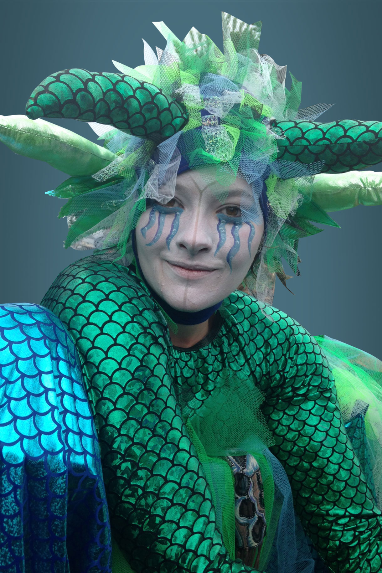 Theatrical performer kneeling on stilts at a Whitianga festival